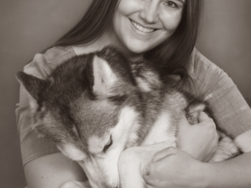 A portrait of a woman hugging her dog