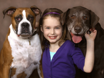 A portrait of  a girl and her two dogs.