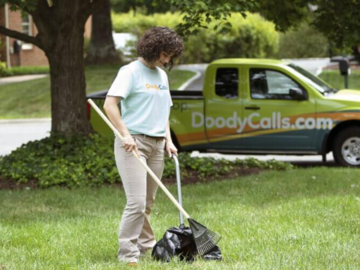 A woman scooping dog waste