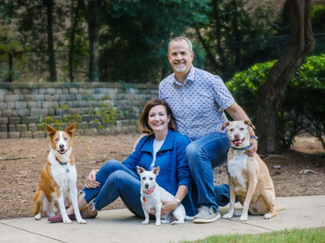 couple with three dogs family portrait at park