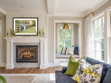 A man & woman stand along a wooden fence with a yellow labrador puppy at their feet in a framed photo above the fireplace in a homey Atlanta living room.